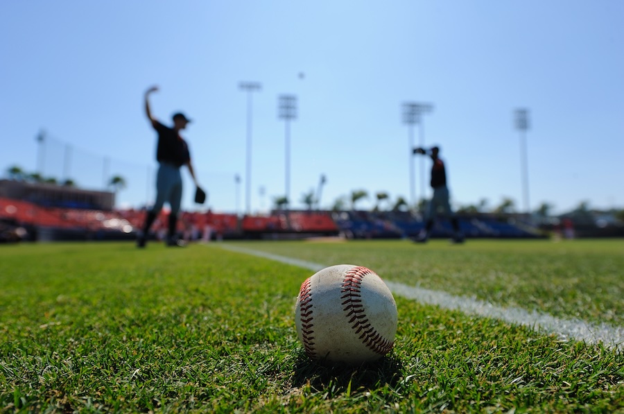 Baseball players warn-up in the outfield before a game.