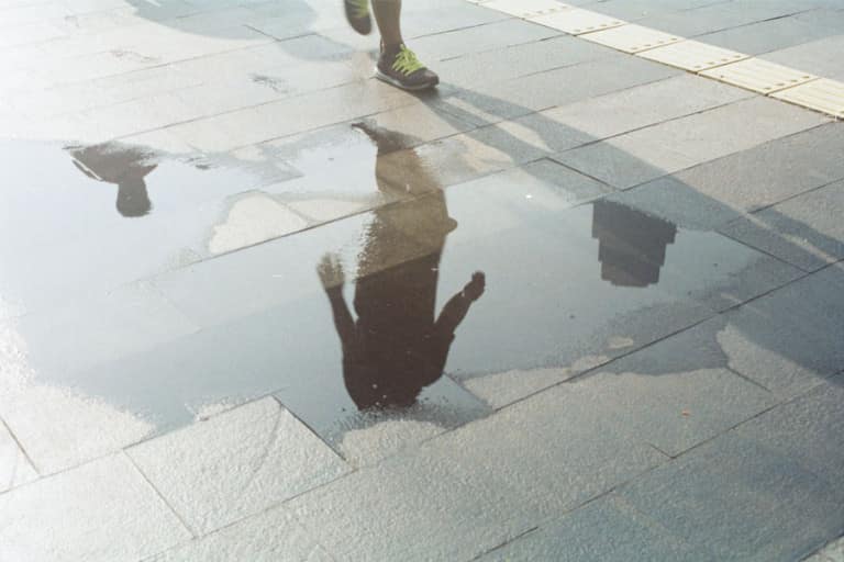 An image of a person about to step into a puddle on a pavement