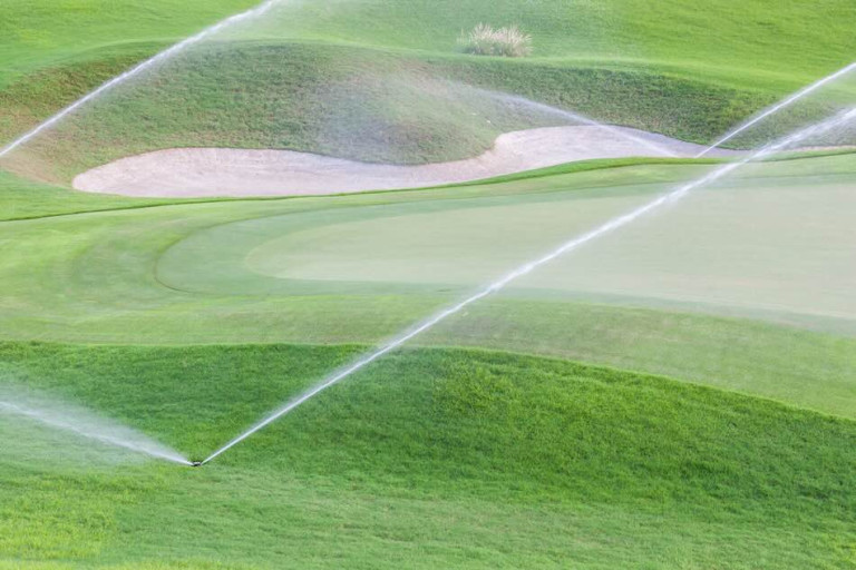 Irrigation spraying water on to the grass at a golf course