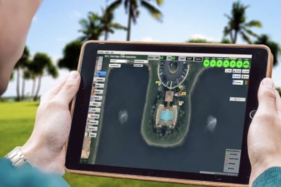 Someone using the Flowguard app on a tablet whilst overlooking a golf course