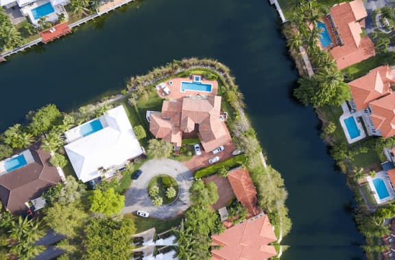 Looking down on a house within a housing community that is surrounded by water