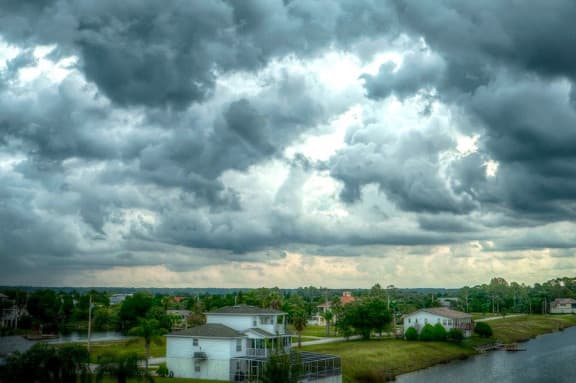 Cloudy skies above a housing estate with trees