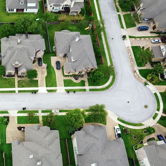 Looking down on a road within a housing community with houses and gardens