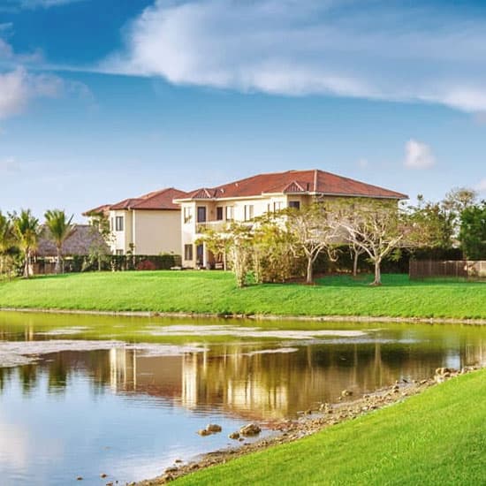 Housing surrounded by grass and water