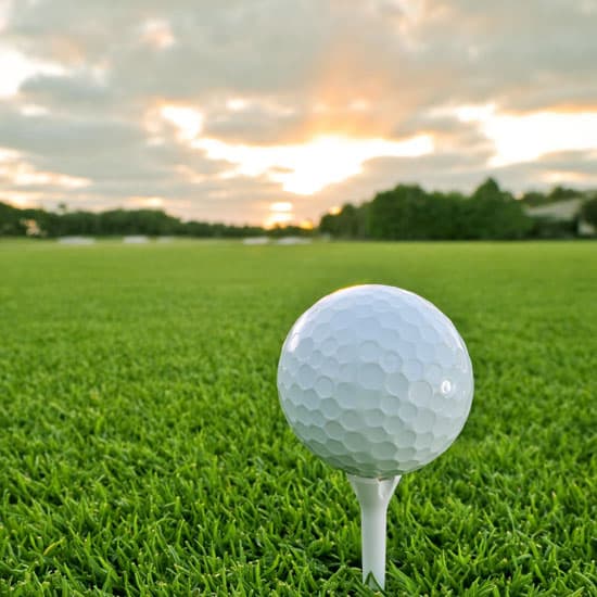 Close up of a golf ball on a tee on a green lawn