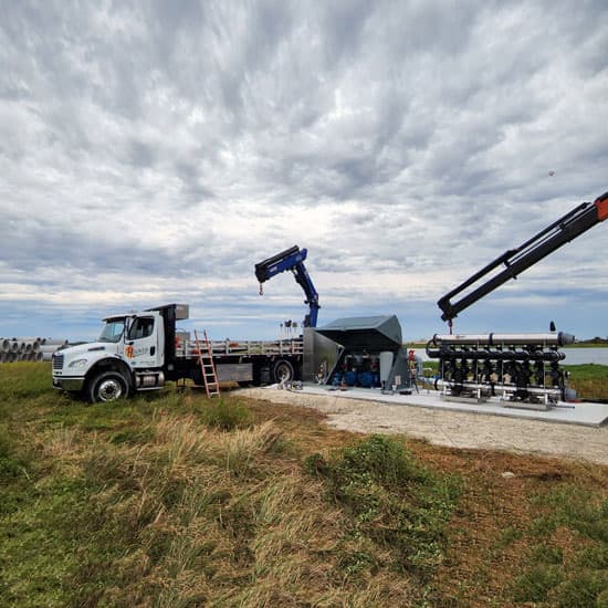 A Hoover truck parked next to an irrigation pump that is being installed