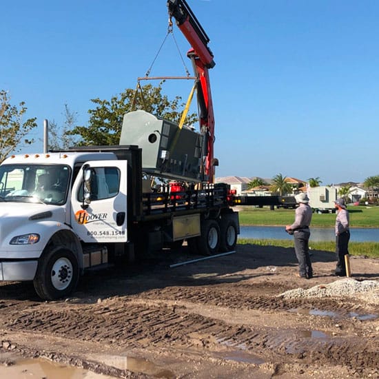 Hoover team using a crane on a truck  to lift an Irrigation Pump Station